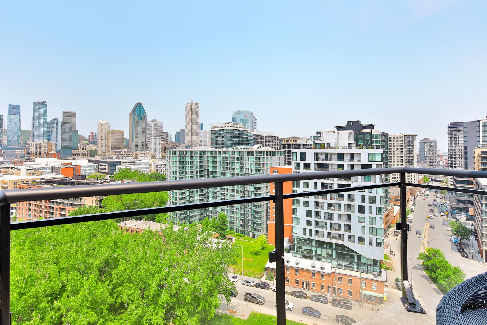 Vue d'une terrasse sur le toit à Griffintown : tours de condos, rue Ottawa et gratte-ciel du centre-ville