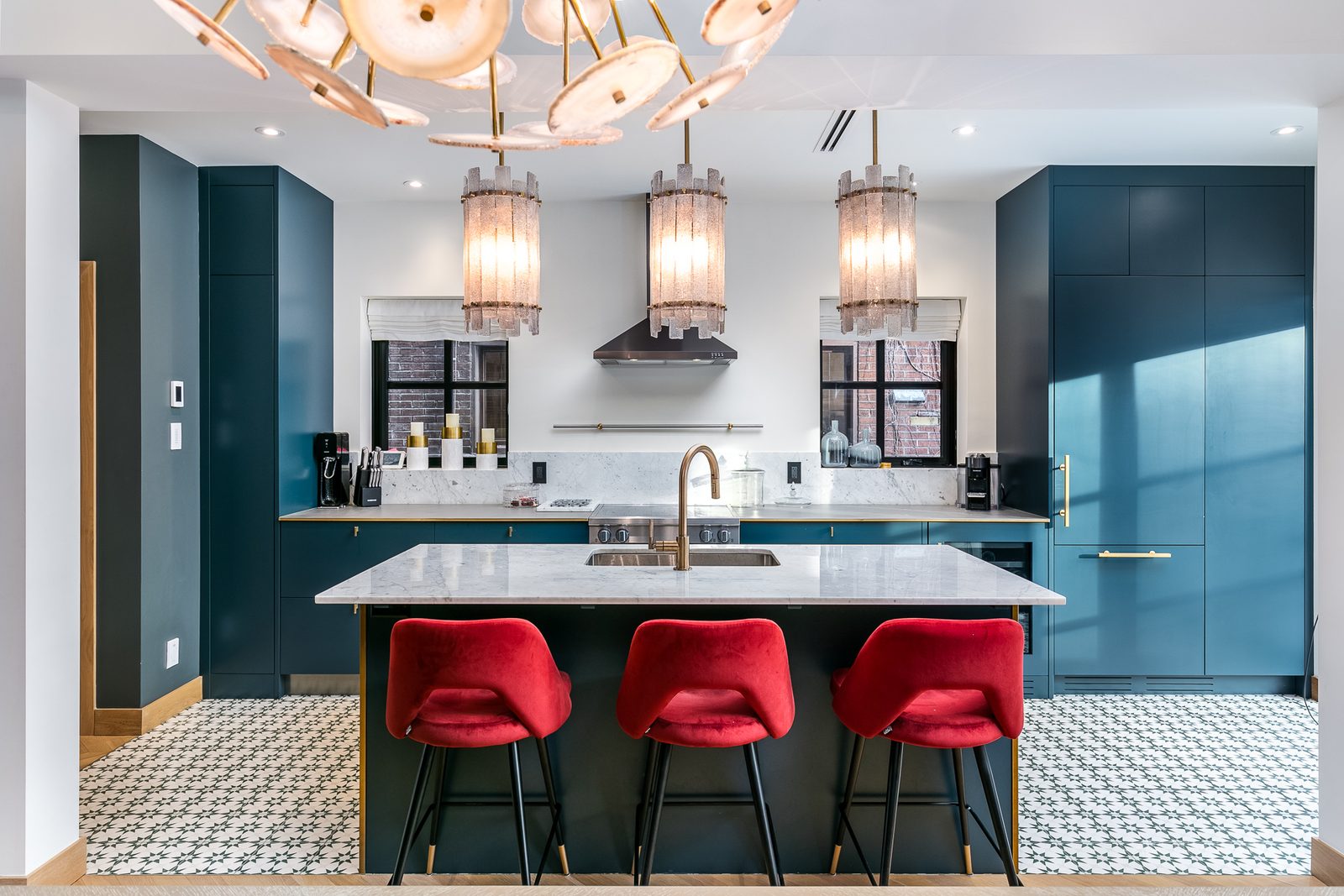 Cuisine rénovée d'une maison d'Outremont, armoires bleu sarcelle, îlot de marbre et tabourets rouges