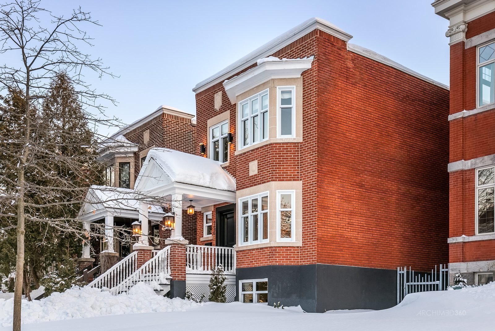 Façade d'une maison d'Outremont en pierre grise sur une rue bordée d'arbres