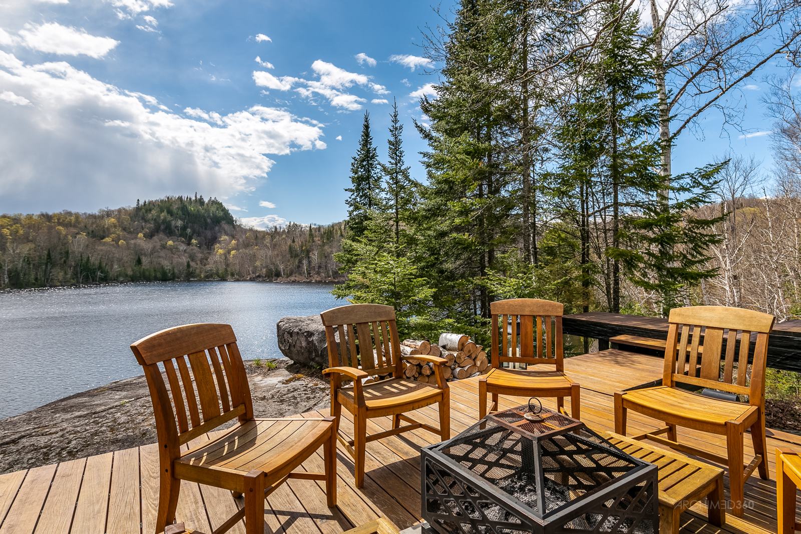 Terrasse avec chaises au bord d'un lac des Laurentides