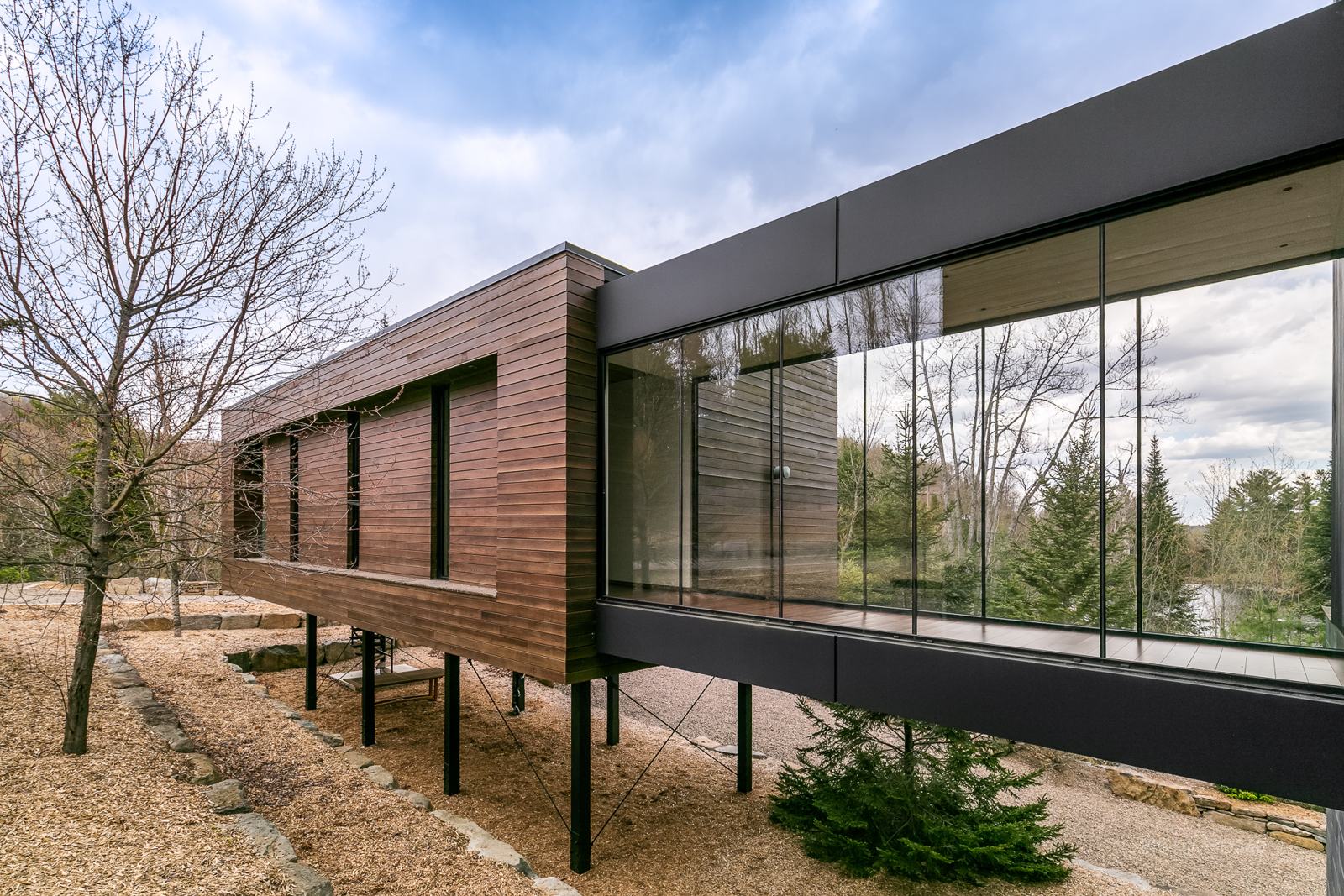 Bâtiment contemporain en bois et verre sur pilotis